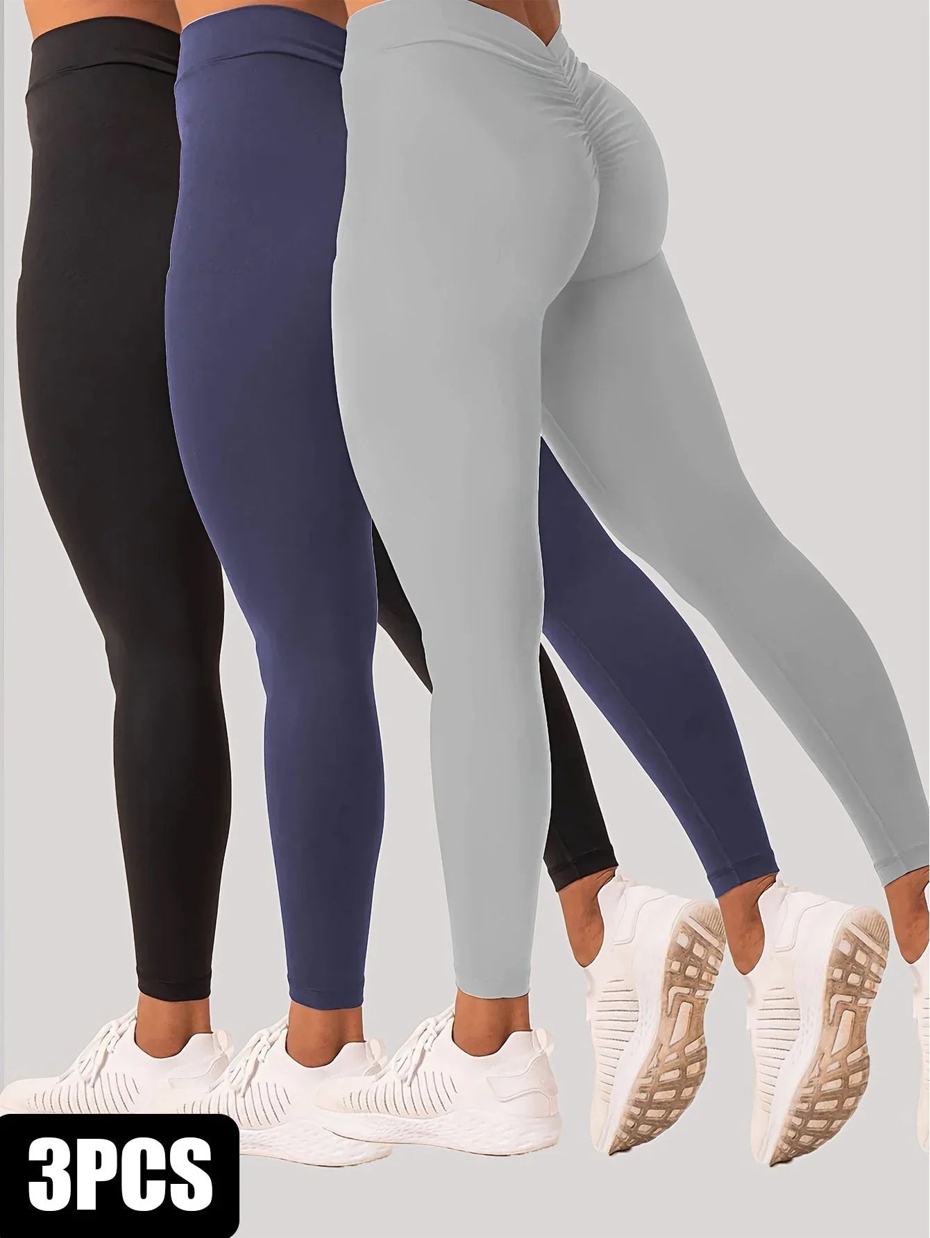Set of three high-waisted yoga leggings in black, navy, and grey with white sneakers