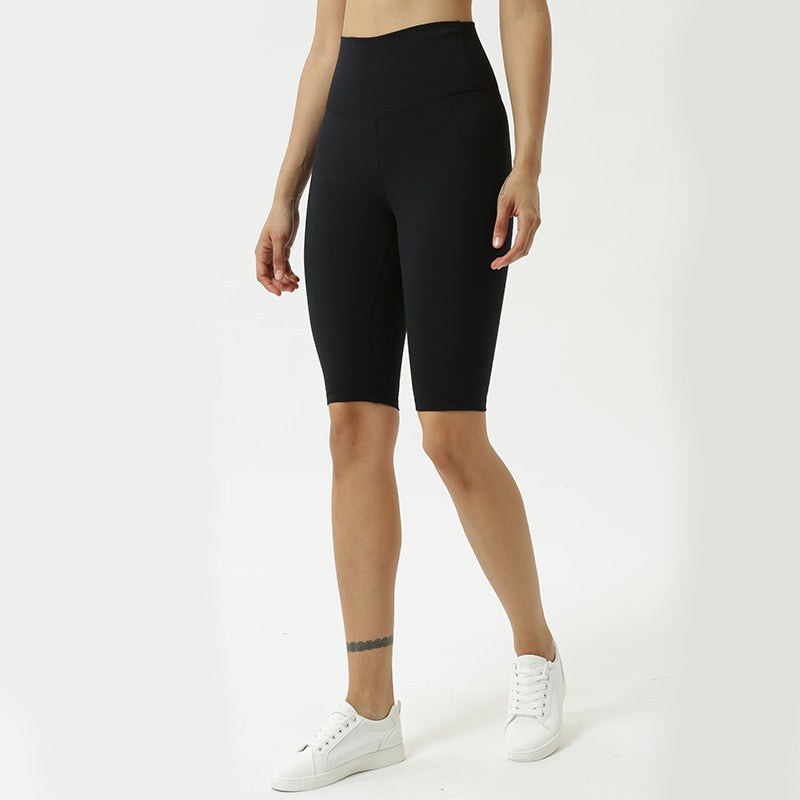 Person wearing black high-waisted leggings on a white background
